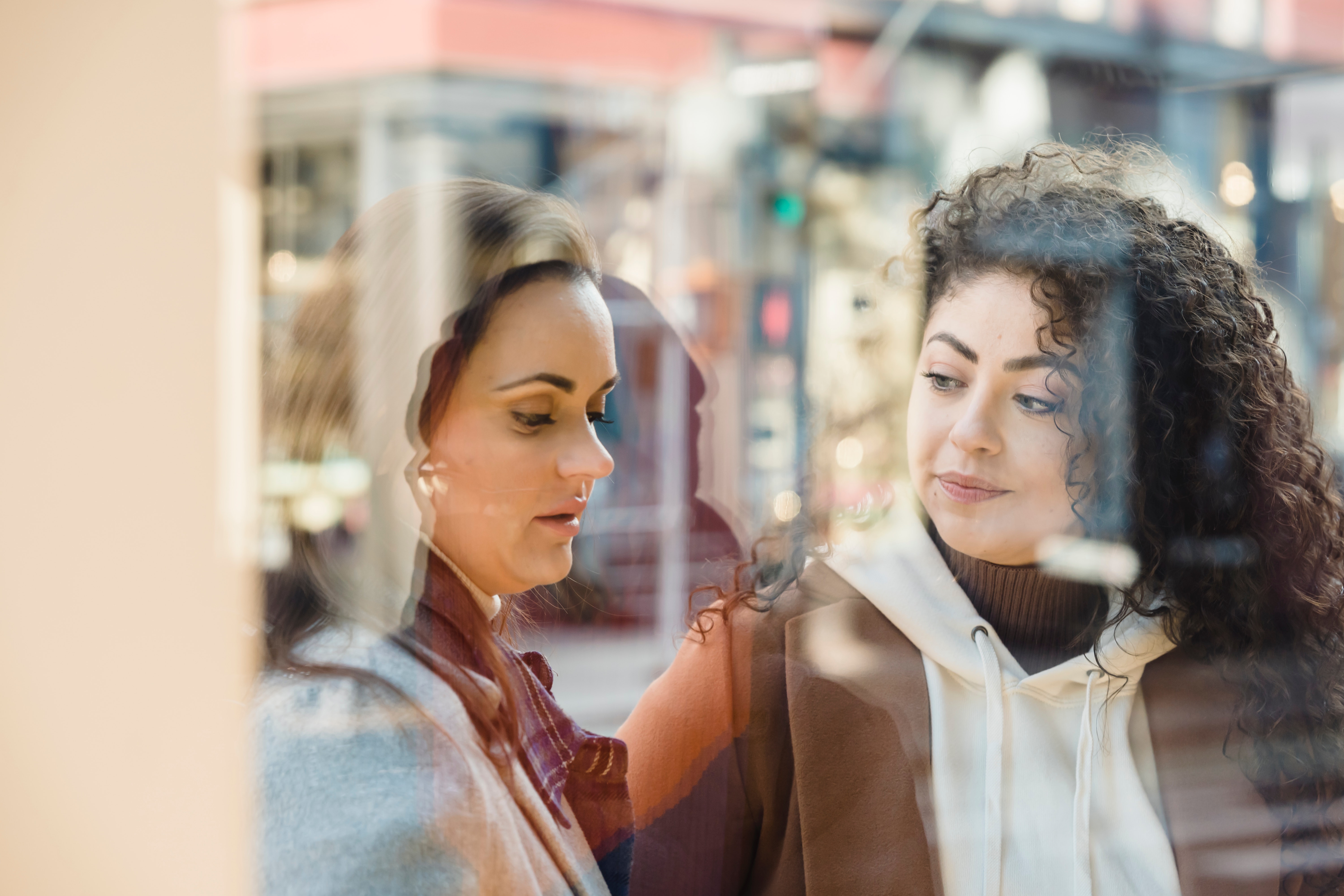 Twee vrouwen door venster vitrine