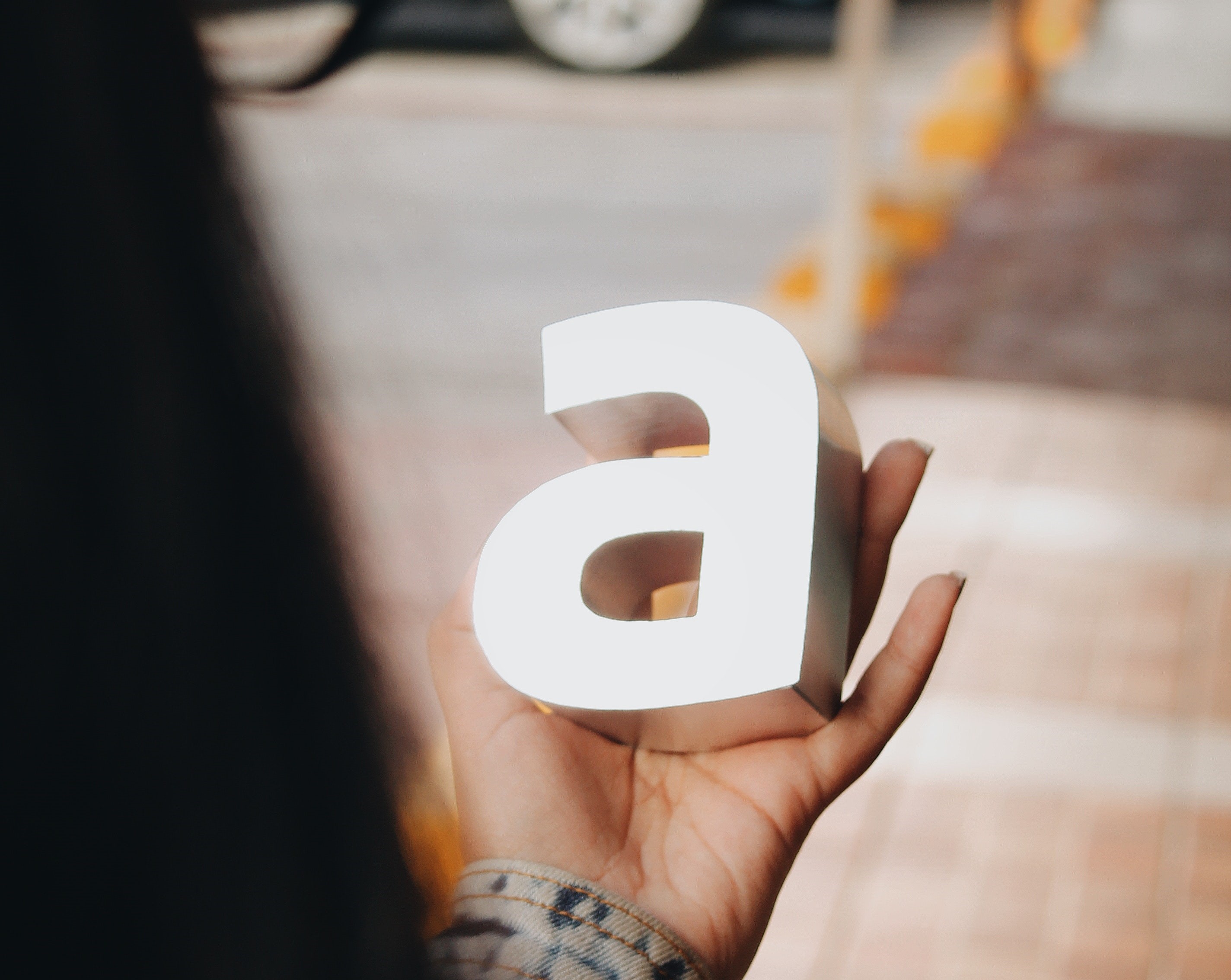 Vrouw houdt driedimensionale witte letter a in haar hand