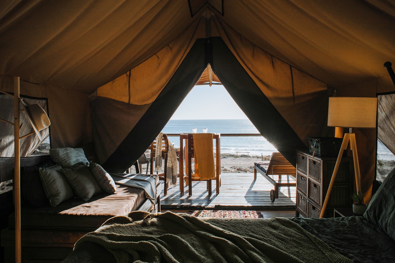 Grote tent met meubels en uitzicht op zee