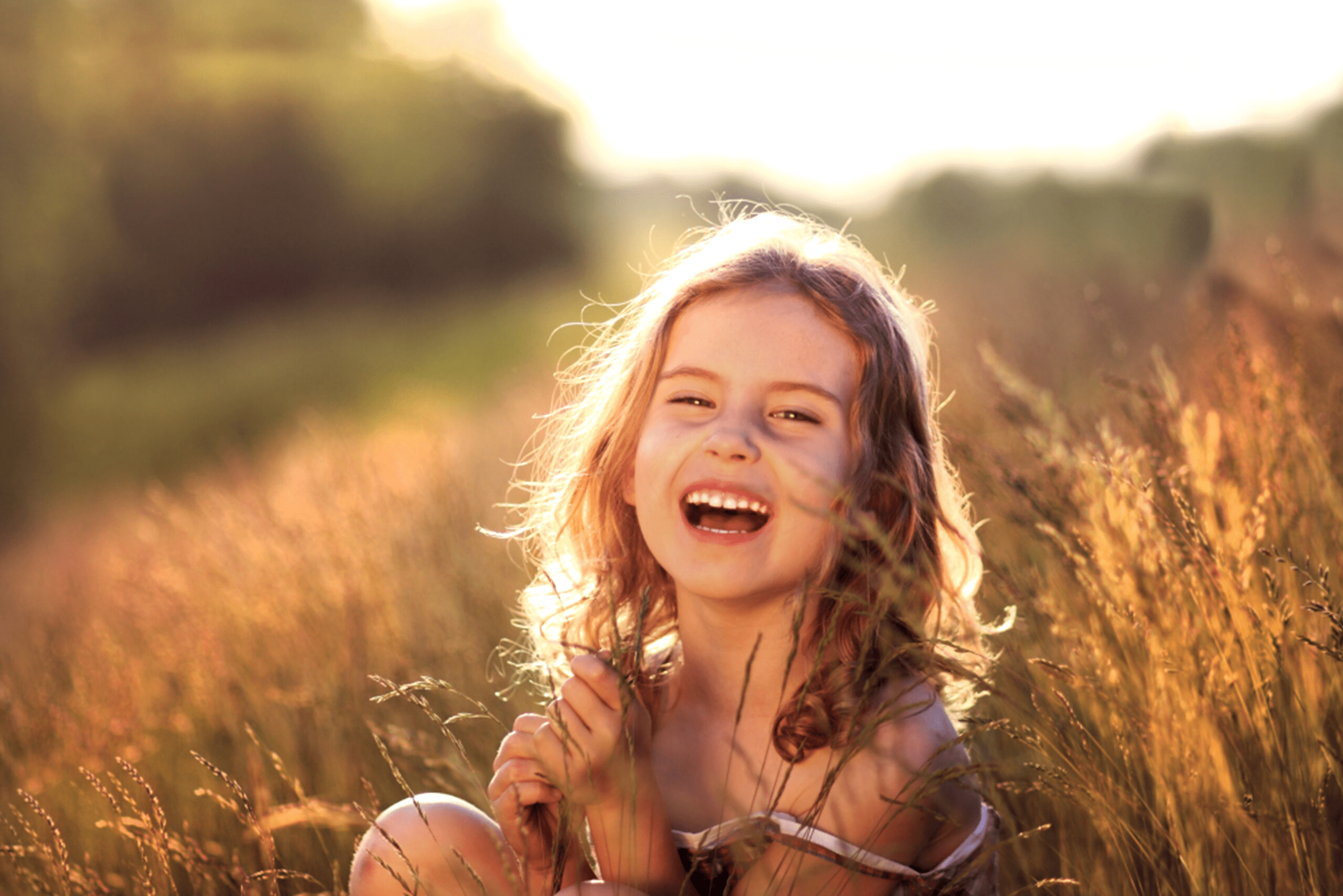 Meisje lacht in een zonnig veld